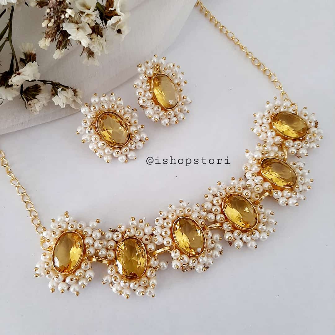 Oval glossy stones and pearls beads necklace in a chic design in golden color.